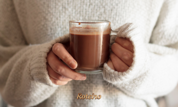 ALT text da imagem: Mãos segurando caneca de chocolate quente cremoso sem amido de milho — receita do Portal Roteiro SJC