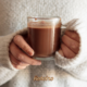 ALT text da imagem: Mãos segurando caneca de chocolate quente cremoso sem amido de milho — receita do Portal Roteiro SJC