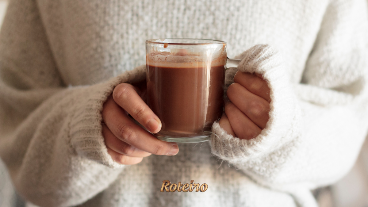 ALT text da imagem: Mãos segurando caneca de chocolate quente cremoso sem amido de milho — receita do Portal Roteiro SJC