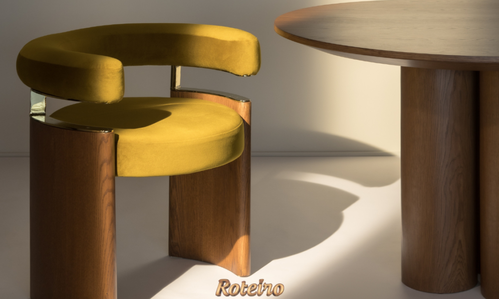 Cadeira Curva BONNI em veludo amarelo mostarda com base em madeira de carvalho e detalhes em latão dourado, ao lado de mesa redonda em madeira — design de Erik Bonissato