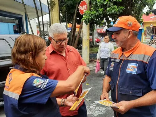 Morador tirando dúvidas com agentes da defesa civil
