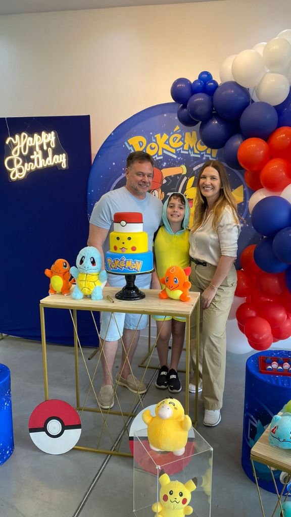 Castro Neto, Rubens Eduardo e Zilma Valadão em frente a mesa do bolo