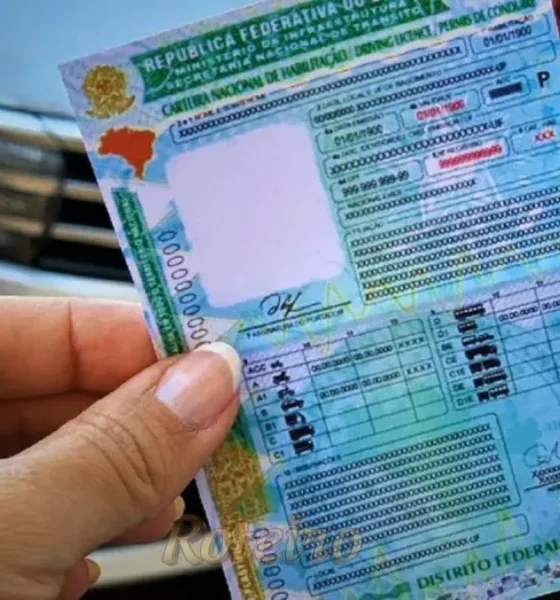 uma mão feminina segunrando uma cnh