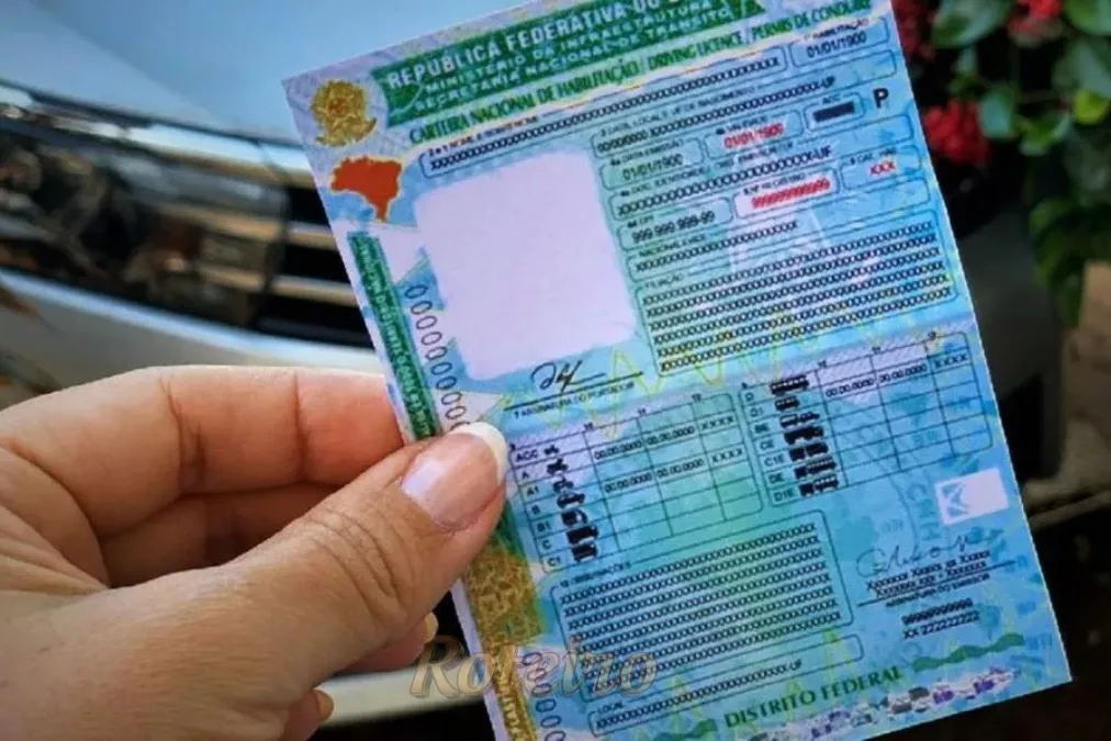 uma mão feminina segunrando uma cnh