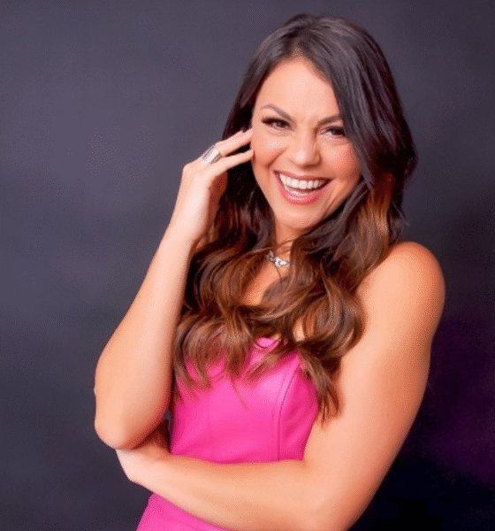 Humorista Bruna Louise sorrindo no palco durante apresentação de stand-up comedy.