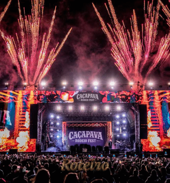Estrutura gigante da arena e palco do Caçapava Rodeio Fest 2026, capturada à noite com iluminação cênica. A foto destaca a capacidade de público para os shows de Simone Mendes, Alok e Zé Neto & Cristiano, reforçando a importância do evento para o turismo e entretenimento regional no RoteiroSJC