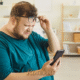 Homem obeso olha para a tela do celular com expressão de dúvida e estranhamento. Foto de capa para matéria sobre os cuidados no Dia Mundial da Obesidade.
