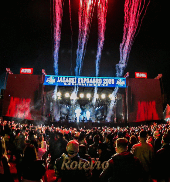 Vista panorâmica da arena lotada durante show na Jacareí Expo Agro do ano passado, destacando o palco iluminado, a grande estrutura de som e o público celebrando o maior rodeio do Vale do Paraíba.