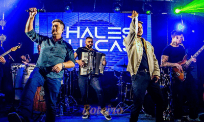 Dupla sertaneja Thales e Lucas em show no palco, com iluminação cênica. Imagem de destaque para a matéria sobre a gravação do DVD Degrau em São José dos Campos (SJC).