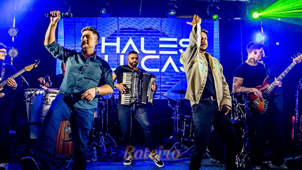 Dupla sertaneja Thales e Lucas em show no palco, com iluminação cênica. Imagem de destaque para a matéria sobre a gravação do DVD Degrau em São José dos Campos (SJC).