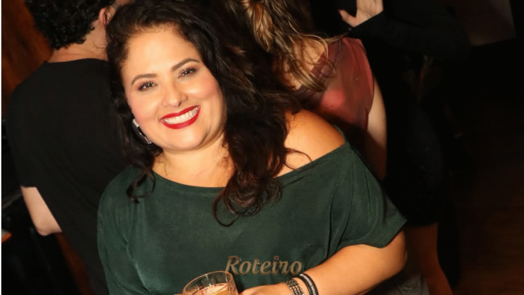 Elaine Calle de vestido verde, com um drink na mão comemorando seus 51 anos