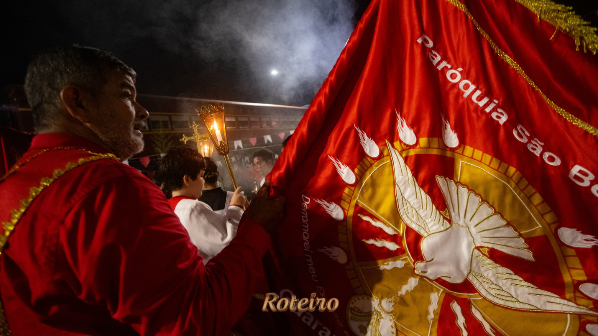 Procissão noturna da Festa do Divino Espírito Santo 2026 com bandeira da Paróquia São Benedito em Guararema SP — foto Warley Kenji Comunicação PMG