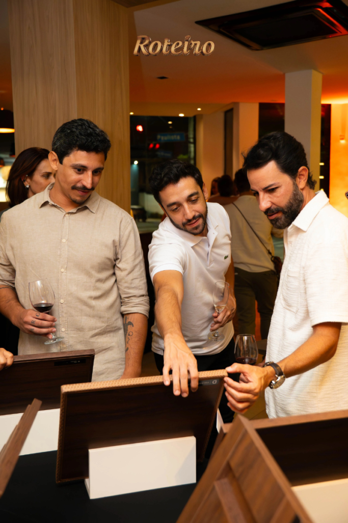 Arquitetos e designers observam amostras de acabamento expostas na mesa durante o evento da Dalmóbile SJC 2026