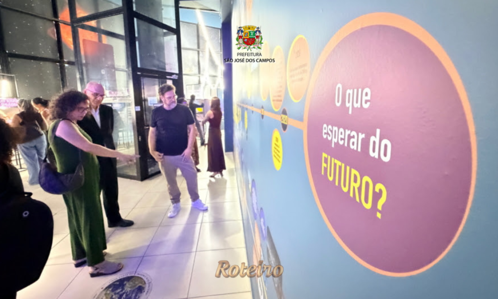 Visitantes observam painel interativo da exposição Raios! Mensageiros do Cosmos no Museu Interativo de Ciências de São José dos Campos, com destaque para o círculo roxo com a pergunta "O que esperar do FUTURO?"