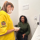 Profissional de saúde com uniforme amarelo e máscara da Prefeitura de São José dos Campos realiza atendimento a paciente sentada em consultório do Hospital de Clínicas Sul