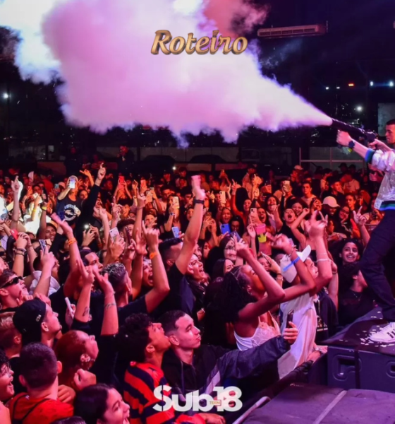 Artista no palco da festa Sub-18 Teen dispara canhão de fumaça colorida sobre multidão de adolescentes animados com os braços erguidos, durante evento noturno ao ar livre em São José dos Campos. Logo Sub-18 Teen visível na parte inferior da imagem. Foto: Divulgação