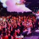 Artista no palco da festa Sub-18 Teen dispara canhão de fumaça colorida sobre multidão de adolescentes animados com os braços erguidos, durante evento noturno ao ar livre em São José dos Campos. Logo Sub-18 Teen visível na parte inferior da imagem. Foto: Divulgação