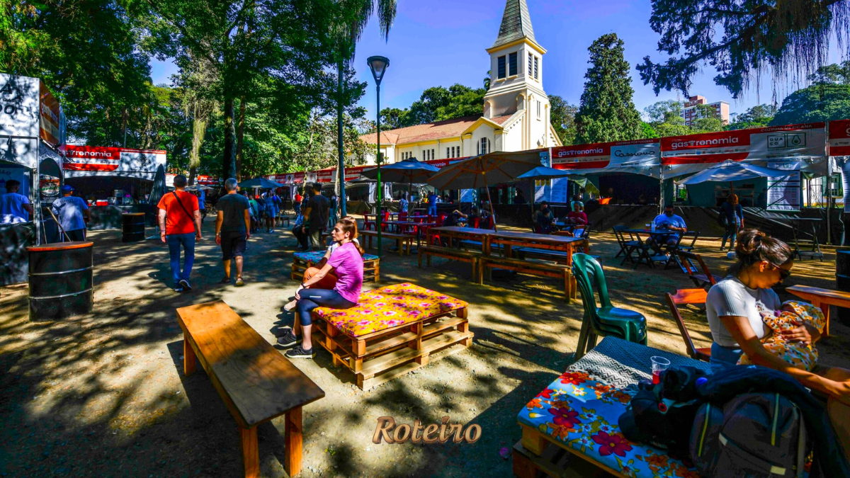Público circulando entre as barracas do Festival Mais Gastronomia no Parque Vicentina Aranha com a Capela ao fundo em São José dos Campos — foto Roteiro SJC