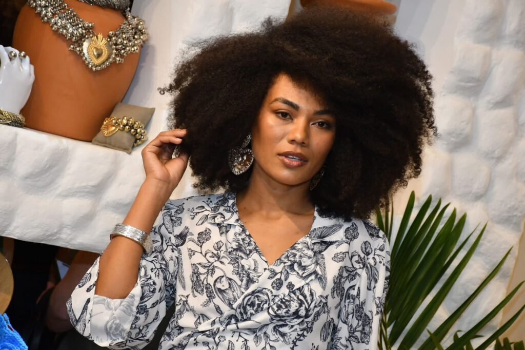 Modelo com cabelo black power e blusa floral posa durante desfile de novas peças no evento de aniversário da Gregga Store em São José dos Campos.