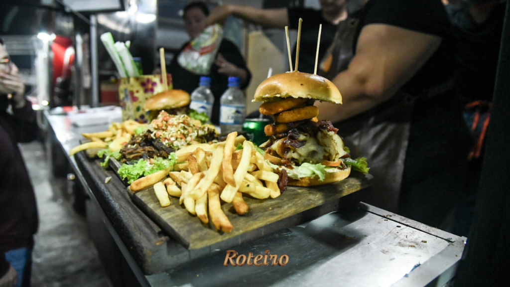Hambúrguer artesanal com batata frita servido em tábua no espaço gastronômico do Guararema Jazz & Blues Festival — foto Warley Kenji Roteiro SJC