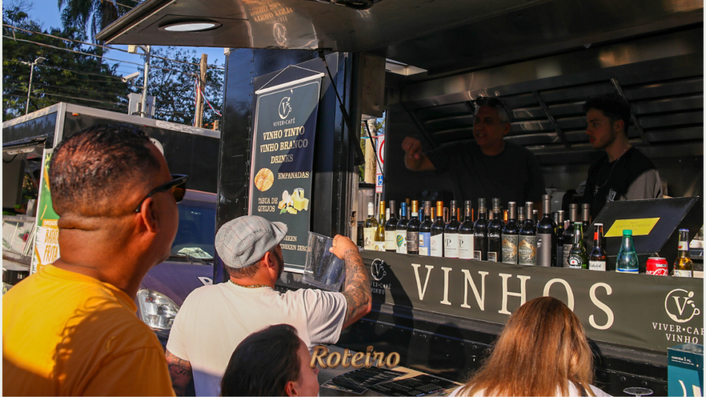 Food truck de vinhos com garrafas expostas e público sendo atendido no Guararema Jazz & Blues Festival — foto Warley Kenji Roteiro SJC