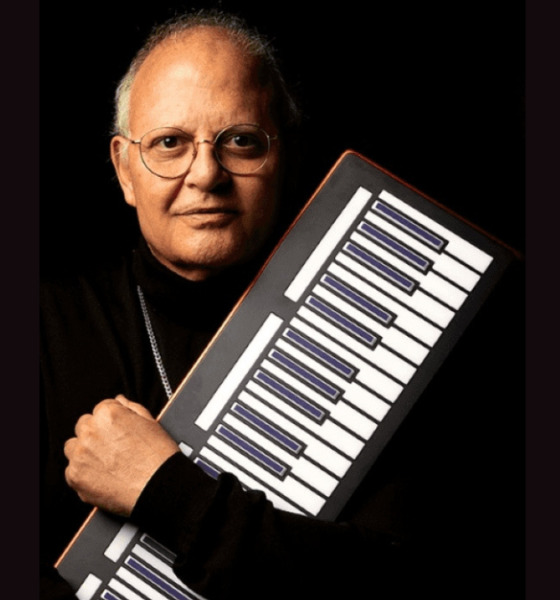Guilherme Arantes segurando teclado portátil em foto de divulgação da turnê 50 Anos Luz em SJC