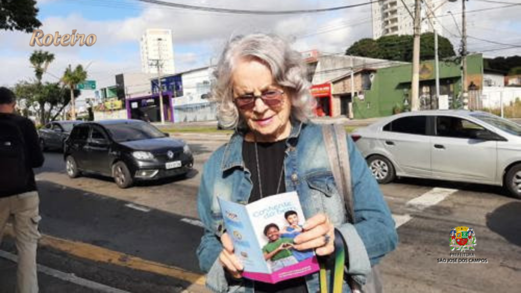 Moradora segura material informativo da campanha Imposto Solidário em São José dos Campos SJC