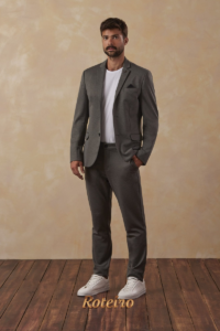 Homem com conjunto de alfaiataria cinza e tênis branco — visual casual chic da moda outono/inverno 2026 SJC