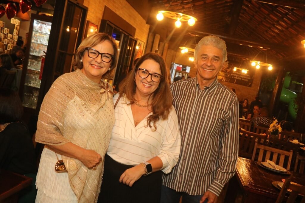 Trio de convidados sorridentes posa no interior iluminado da Fazenda da Vovó durante a Noite Solidária em São José dos Campos. Foto: @nandojrfotografo