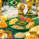 Mesa com petiscos variados e decoração verde e amarela para assistir os jogos da Copa do Mundo 2026 em casa — foto ilustrativa