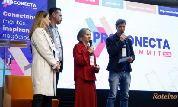 Quatro pessoas em pé no palco do ProConecta Summit 2025, no PIT São José dos Campos. Ao fundo, telão exibe o logo do evento e as trilhas: Audiovisual, Experiência, Comunicação e Design, e Empreendedorismo. Uma mulher de vestido vermelho e um homem de jaqueta preta seguram microfones durante apresentação.