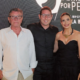 Três convidados posam para foto durante evento comemorativo dos cinco anos do Pátio Villa Branca em Jacareí, com painel "Sempre por Perto" do empreendimento ao fundo