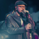 Isaías Saad canta no palco com microfone e jaqueta de couro durante show gospel em Piquete no Vale do Paraíba