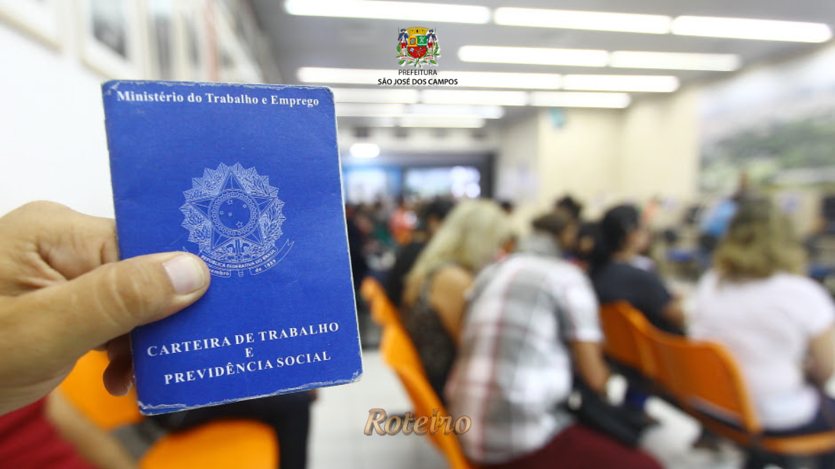 Pessoa segurando Carteira de Trabalho e Previdência Social em sala de espera do PAT de São José dos Campos com candidatos ao fundo