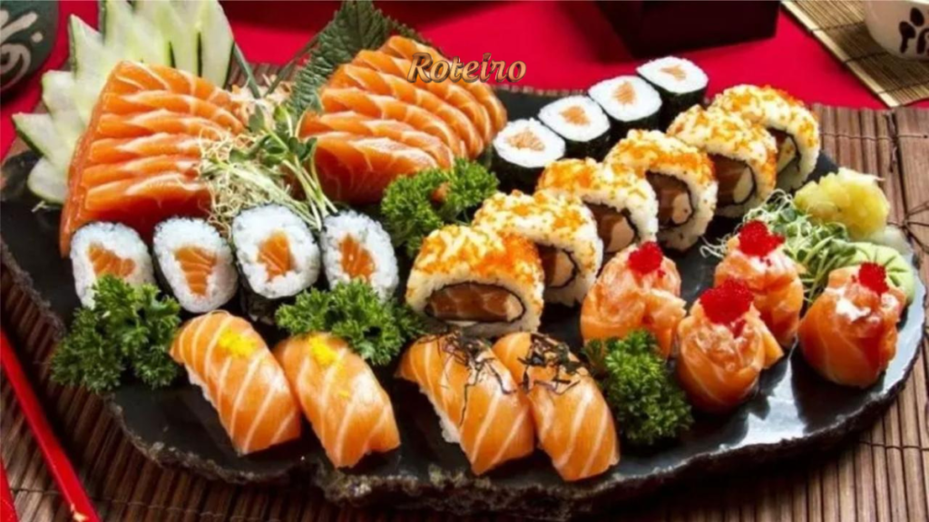 Bandeja variada de sushi e sashimi com fatias de salmão, uramaki, hossomaki e temaki coloridos sobre pedra preta, em imagem de gastronomia japonesa do Vale Ninhon Matsuri. Foto: Divulgação