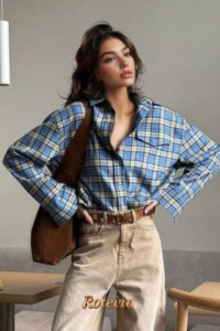 Mulher com camisa xadrez oversized azul e calça bege — estilo retrô moderno da moda outono/inverno 2026 SJC