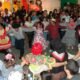 Festas Juninas SJC 2026. Pátio lotado, pessoas a carater dançando