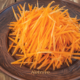 Corte julienne de cenoura em tiras finas sobre tábua de madeira — técnica culinária ensinada pelo Portal RoteiroSJC