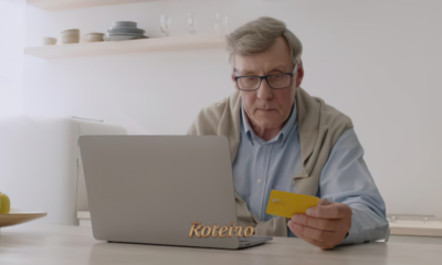Dia da Pessoa Idosa: homem idoso segura cartão de crédito diante do notebook para compra online