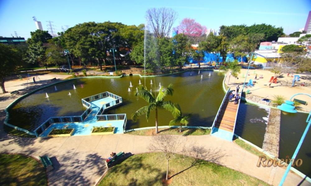 Parque Santos Dumont SJC: lago com chafarizes, ponte de madeira e playground vistos do alto
