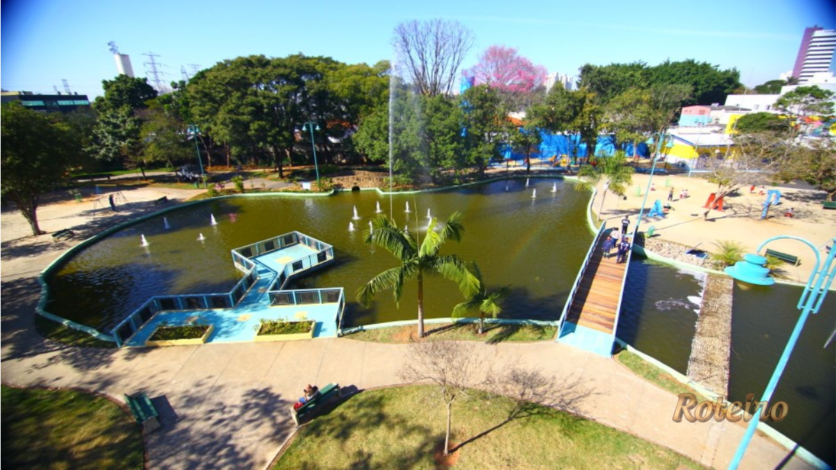 Parque Santos Dumont SJC: lago com chafarizes, ponte de madeira e playground vistos do alto
