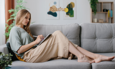 Descobrir quem sou eu: mulher sentada no sofá escreve em um tablet em um momento de pausa em casa