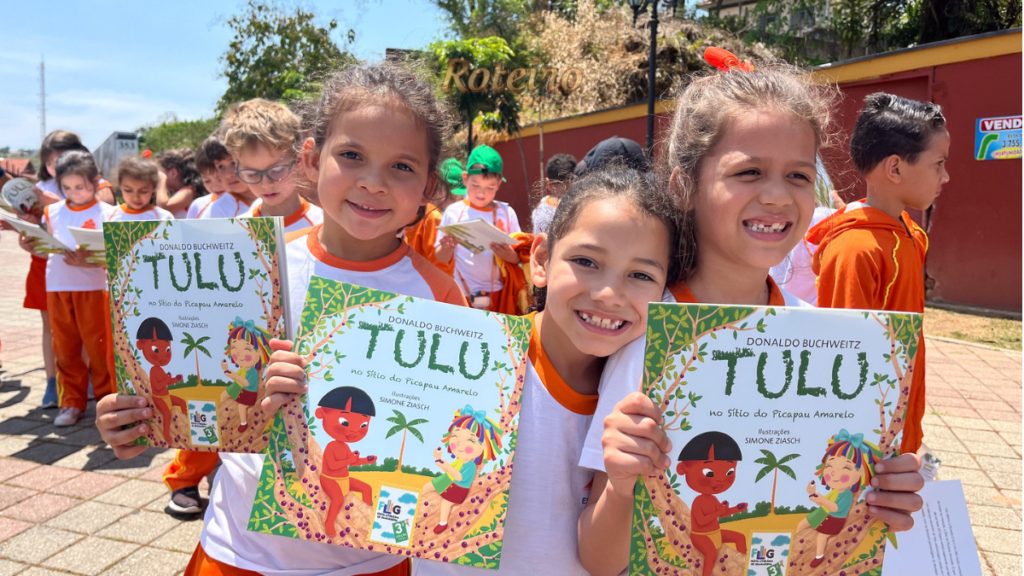 FLIG 2026 em Guararema, alunas mostram livros recebidos em edição anterior da festa