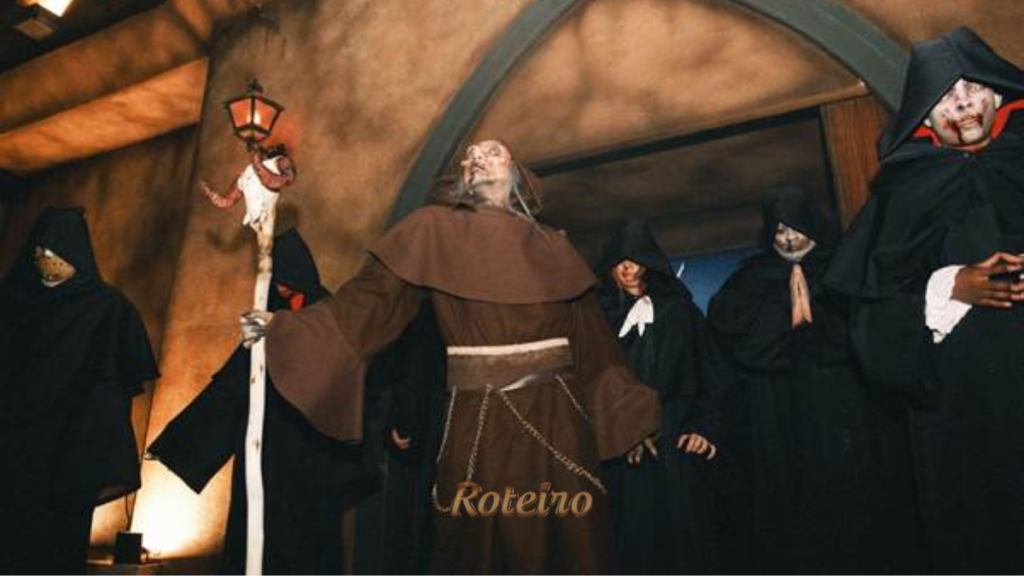 Halloween Castelo do Terror: personagens caracterizados como monge com cajado e lanterna e figuras encapuzadas de preto com rostos pálidos