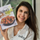 livro da chef Brunelli, Suíno: do tradicional ao extraordinário, nas mãos da autora Flávia Brunelli