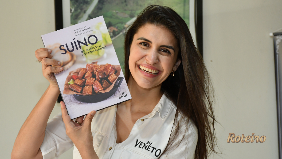 livro da chef Brunelli, Suíno: do tradicional ao extraordinário, nas mãos da autora Flávia Brunelli