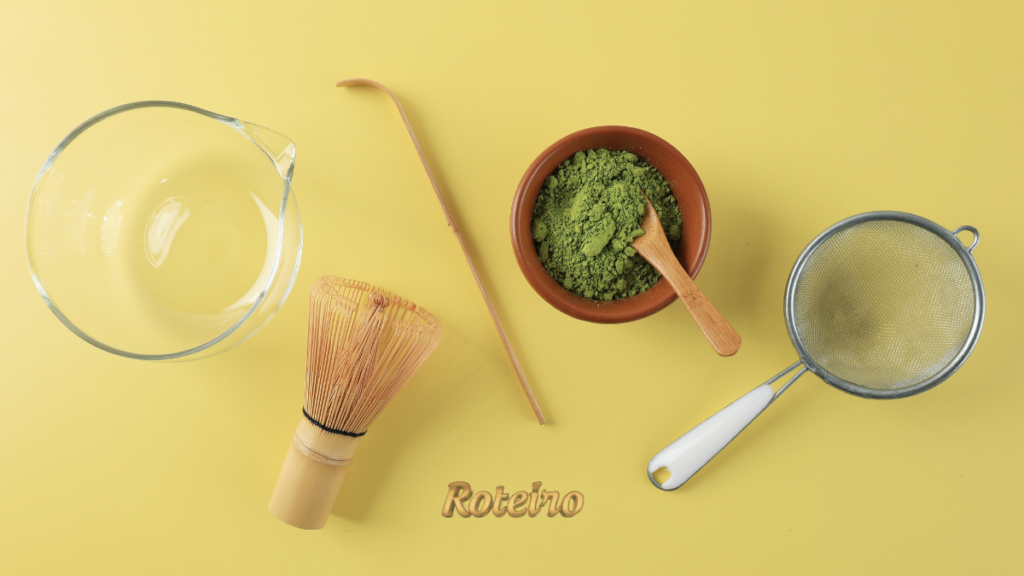 receita de matcha latte, matcha em pó em tigela de cerâmica com chasen, colher de bambu, peneira e jarra de vidro