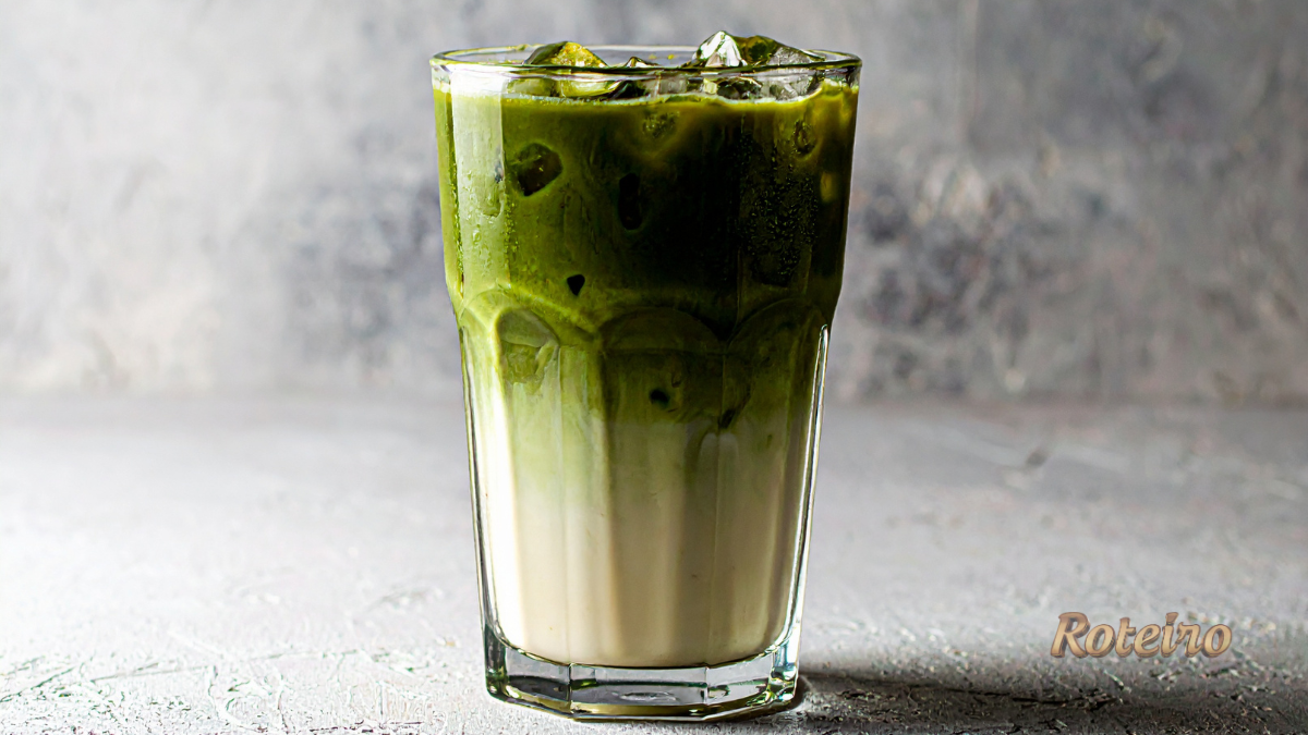 receita de matcha latte gelado em copo alto com gelo e camadas de matcha e leite