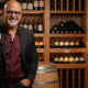 Vinhos no Food Vale: sommelier Edu Santoro com taça de vinho tinto em adega